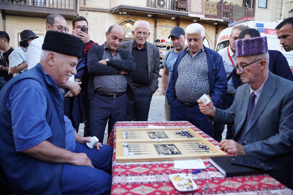 A group of men engaged in an intense game of backgammon outdoors.
