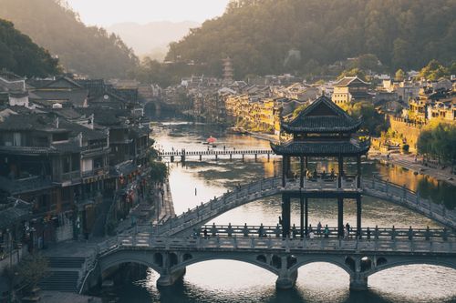 Free Scenic view of Fenghuang Ancient Town by the river at sunset, highlighting its traditional Chinese architecture. Stock Photo