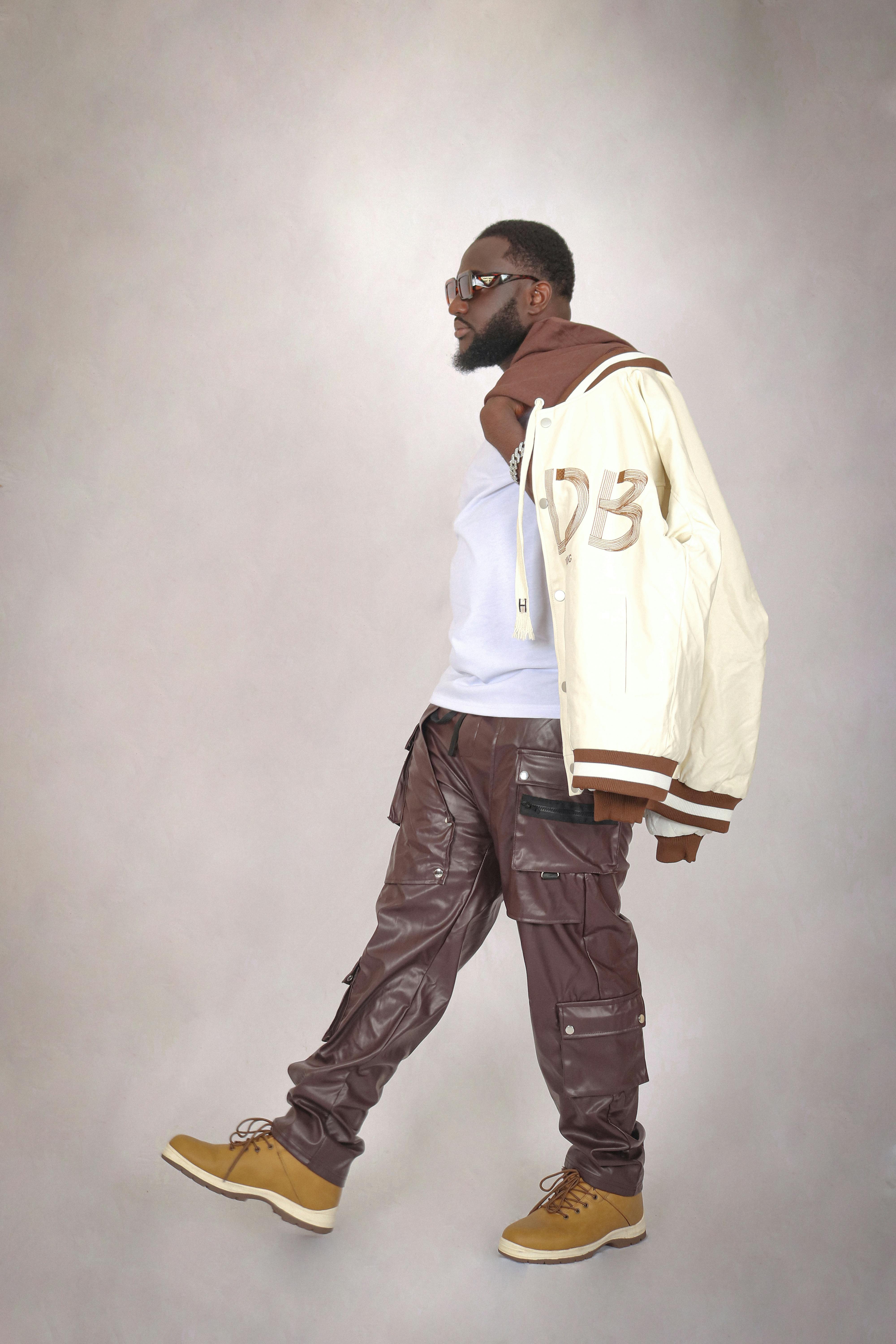 Fashion-forward man in casual streetwear stepping confidently, capturing urban style.