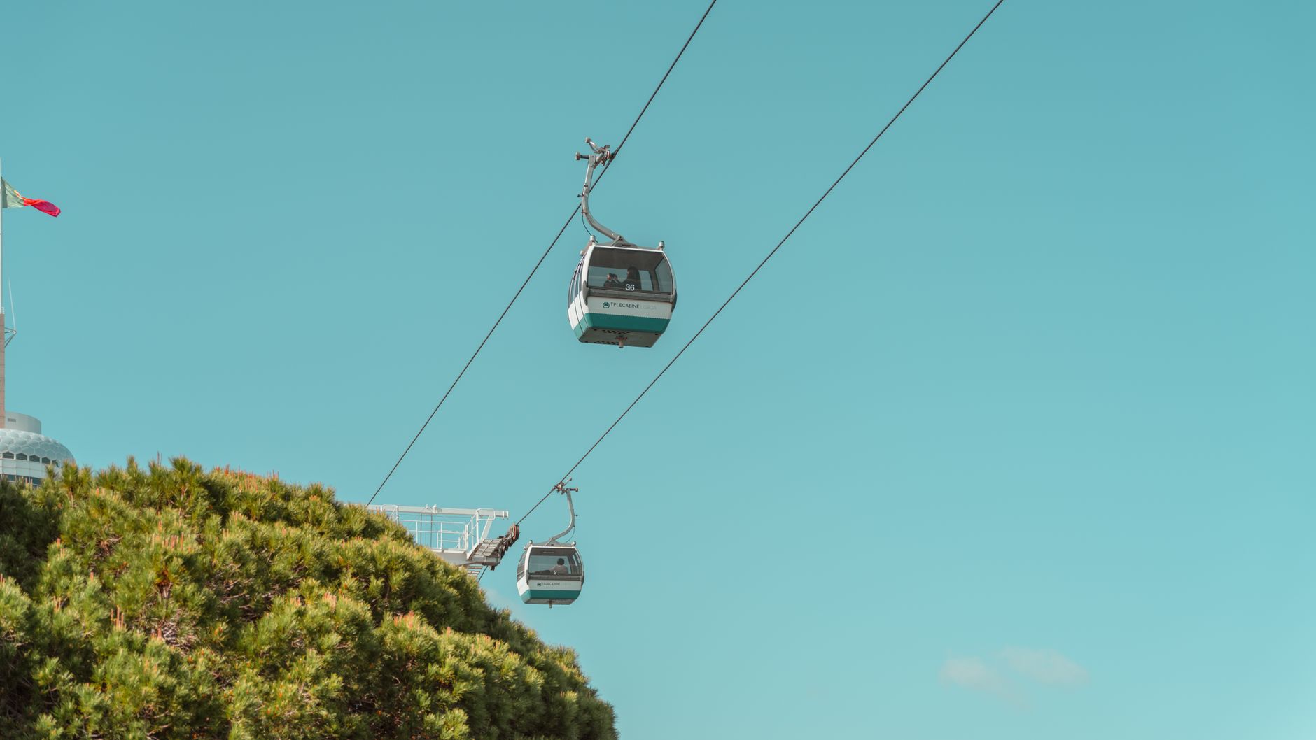 Scenic cable cars in Lisbon, Portugal, against a clear blue sky.