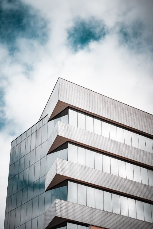 Free Sleek modern office building in Curitiba, Brazil against a blue sky. Stock Photo