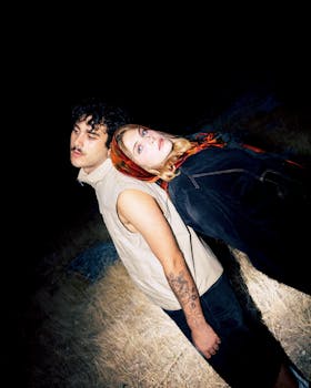 A cinematic portrait of a stylish couple posing at night with grunge aesthetics.