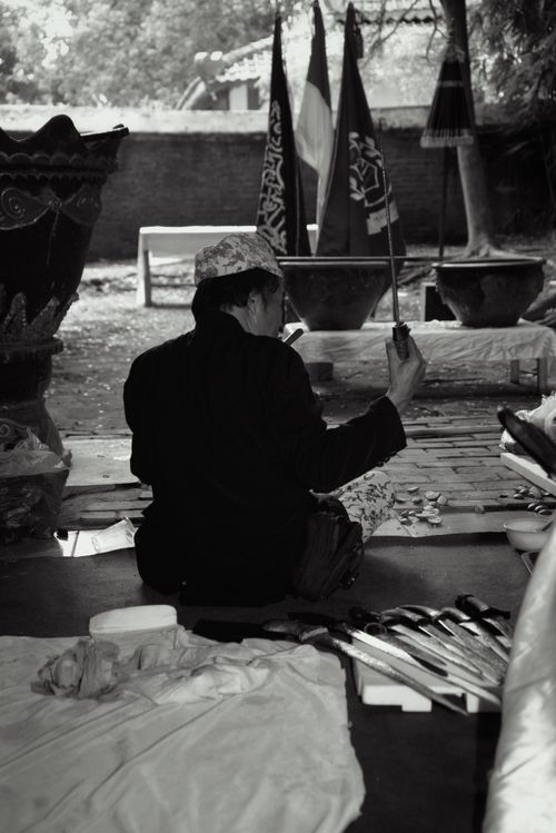 Free Black and white photo of a traditional Indonesian ritual with cultural flags and ceremonial attire. Stock Photo