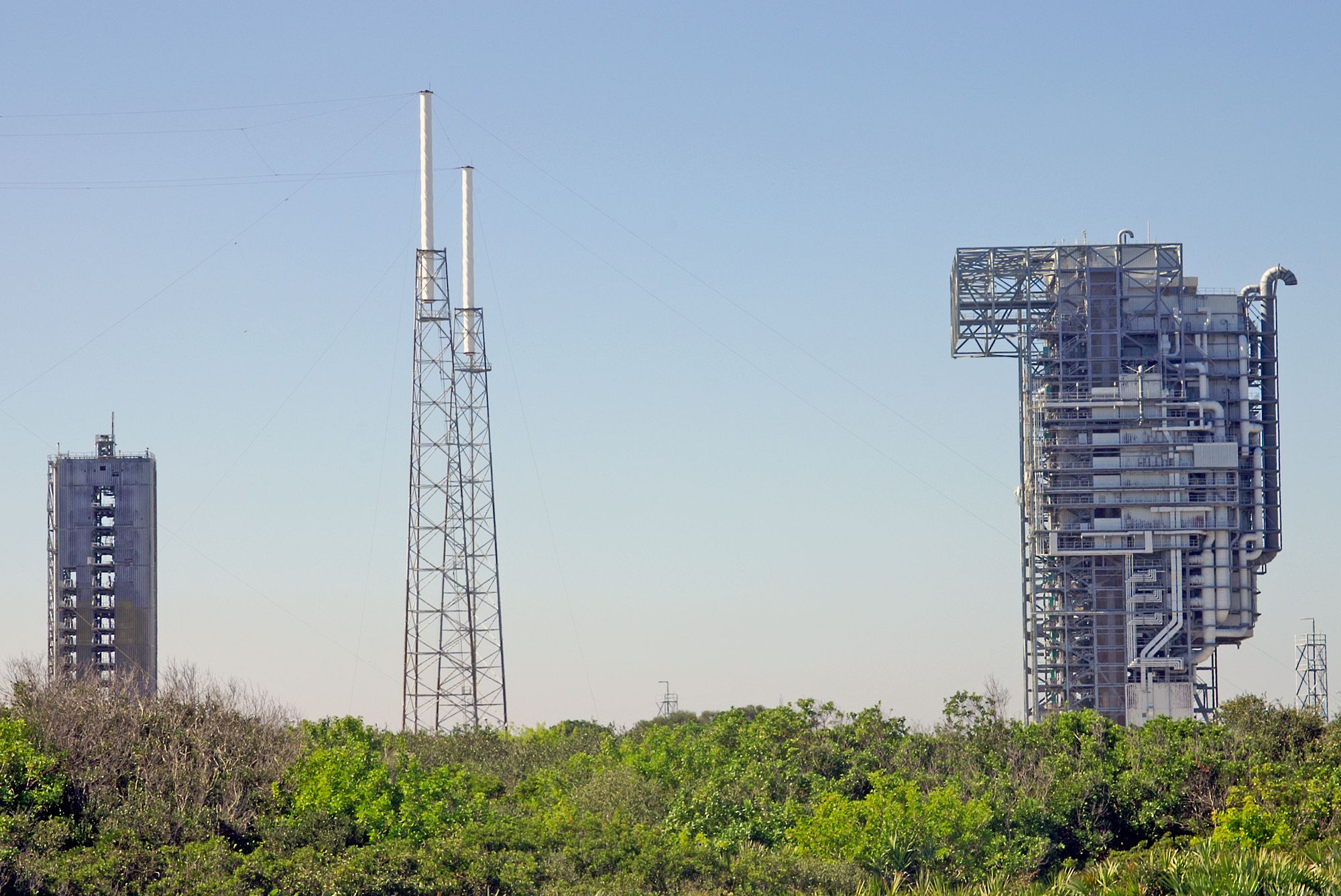 View of rocket launch gantry towers at Kennedy Space Center, Florida under clear sky.