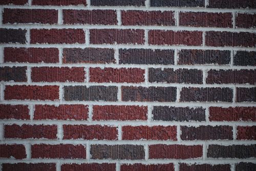 Free Detailed close-up of a red and brown brick wall showing texture and mortar lines. Stock Photo