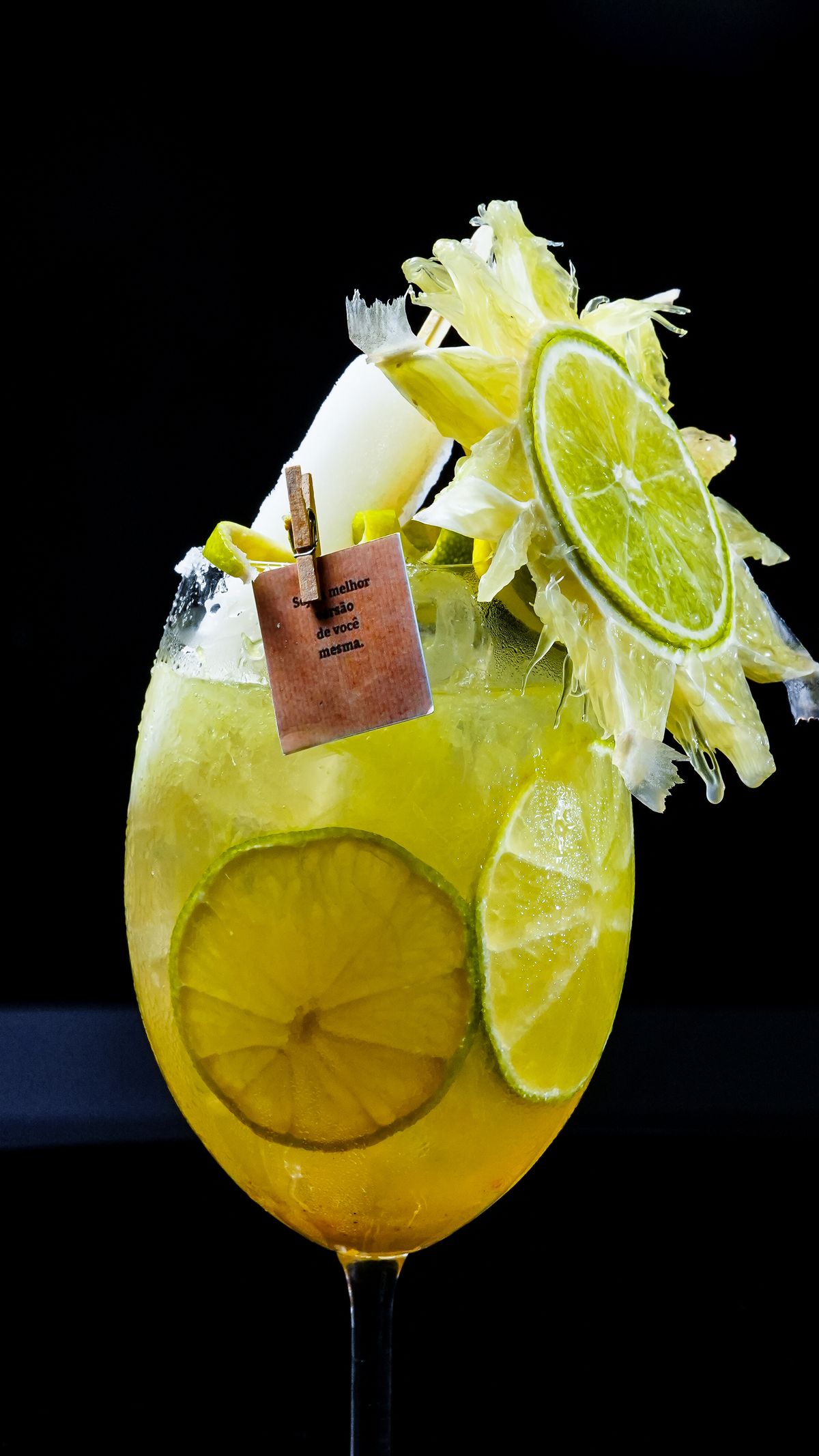 Golden pineapple and lime drink with lime garnish