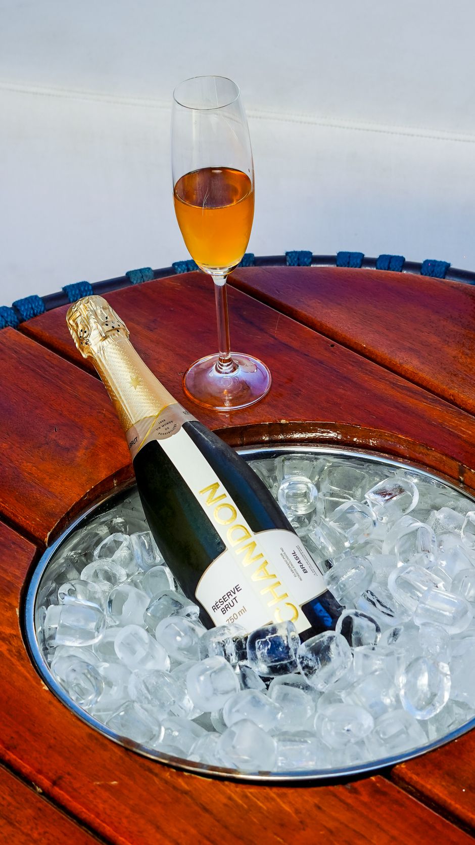 A champagne flute and bottle on ice atop a wooden table, embodying luxury and celebration.