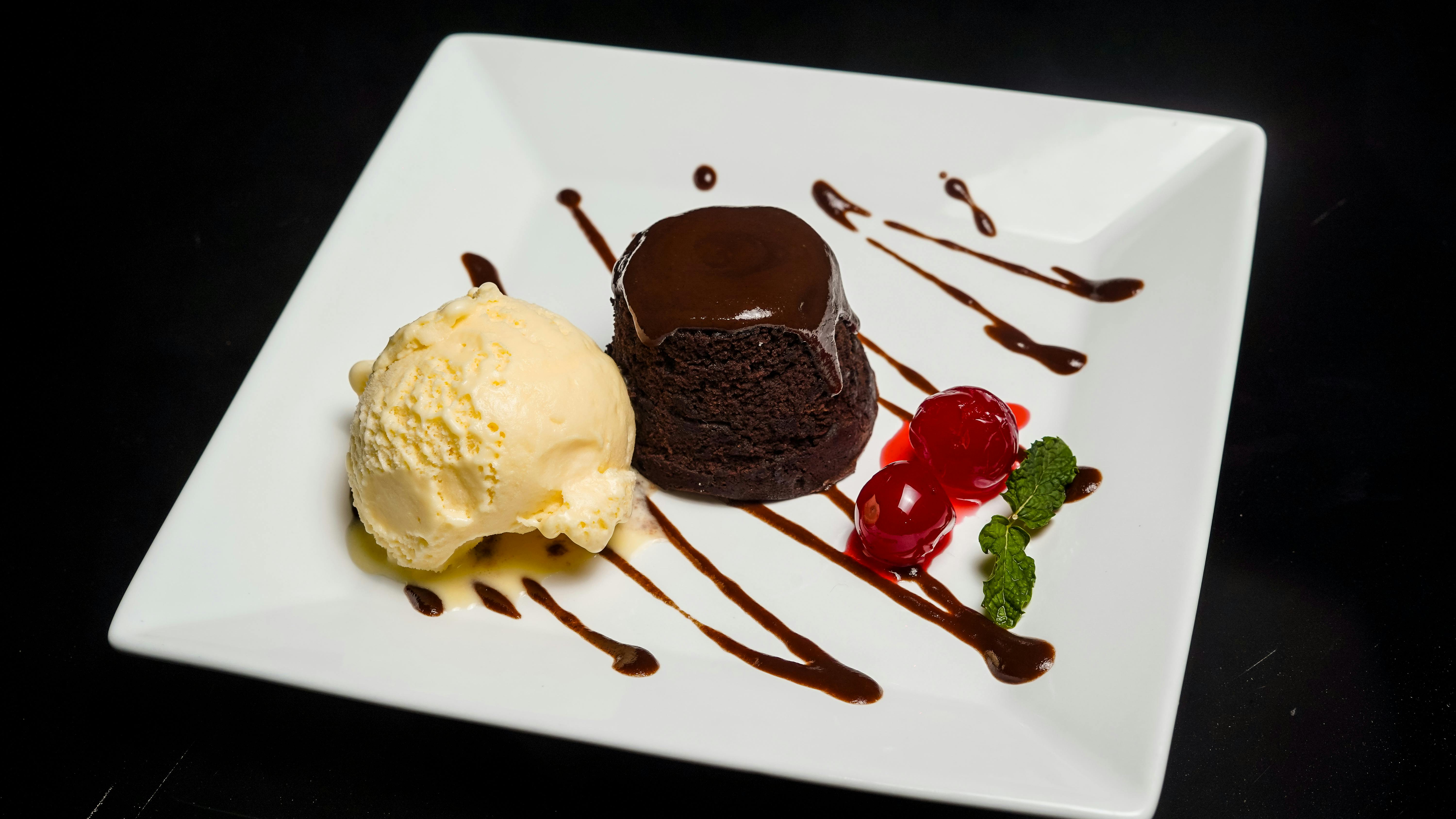 Delicious chocolate cake served with vanilla ice cream and cherries.