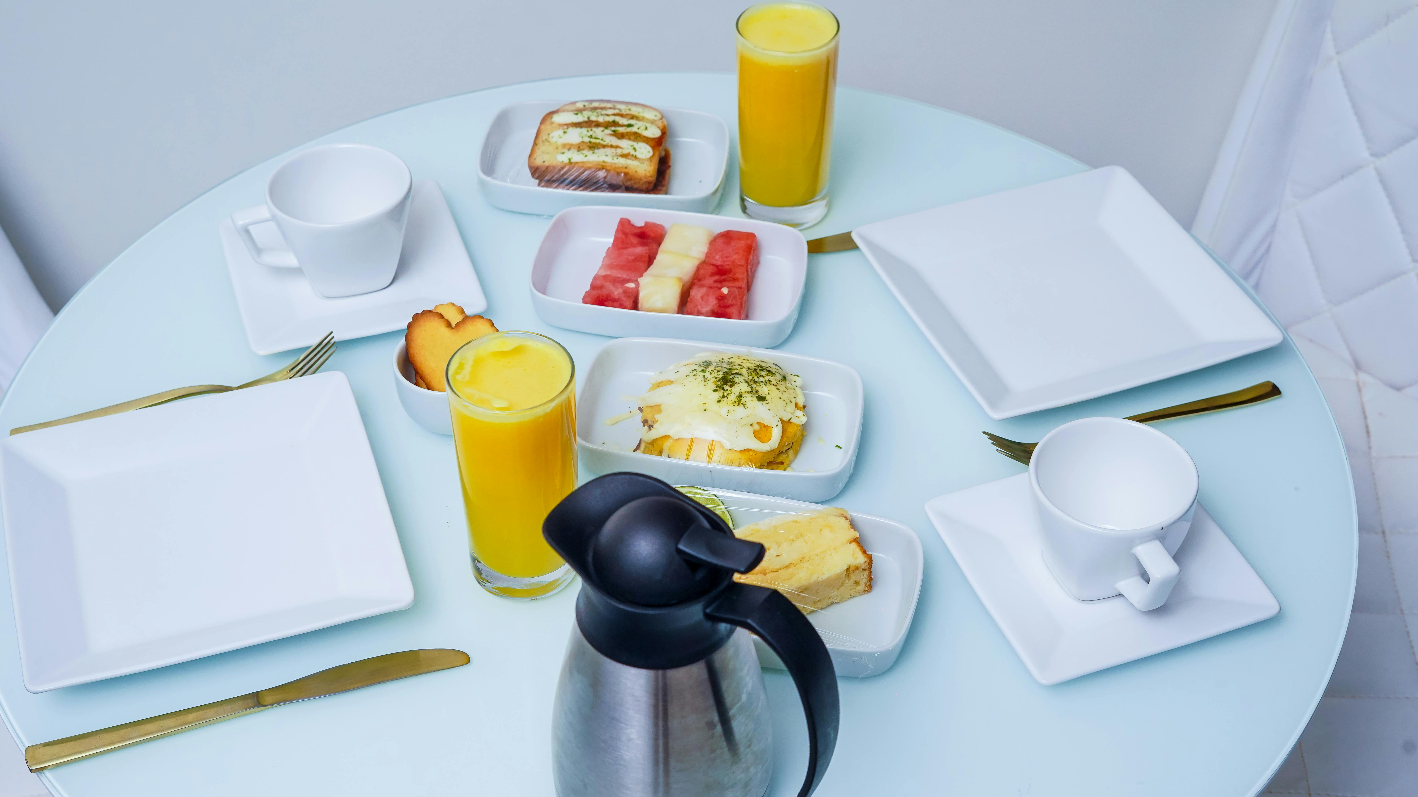 A stylish breakfast table with fresh fruit, pastries, and juice, captured in a modern setting.