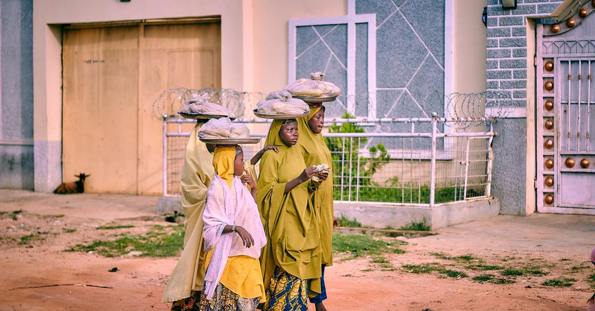 Families walking into a modern church building in Barracks Newtown, Nigeria