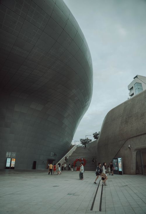 Free Modern architectural marvel of Dongdaemun Design Plaza in Seoul, South Korea with visitors walking around. Stock Photo