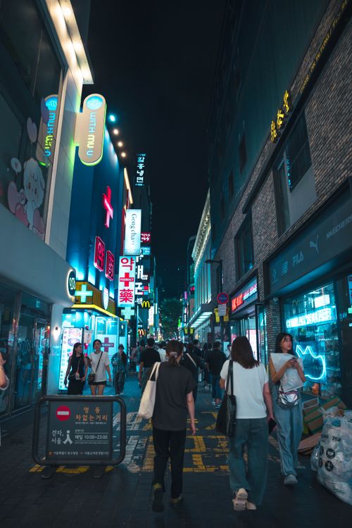 Free Explore a lively Seoul street at night with illuminated signs and bustling activity. Stock Photo