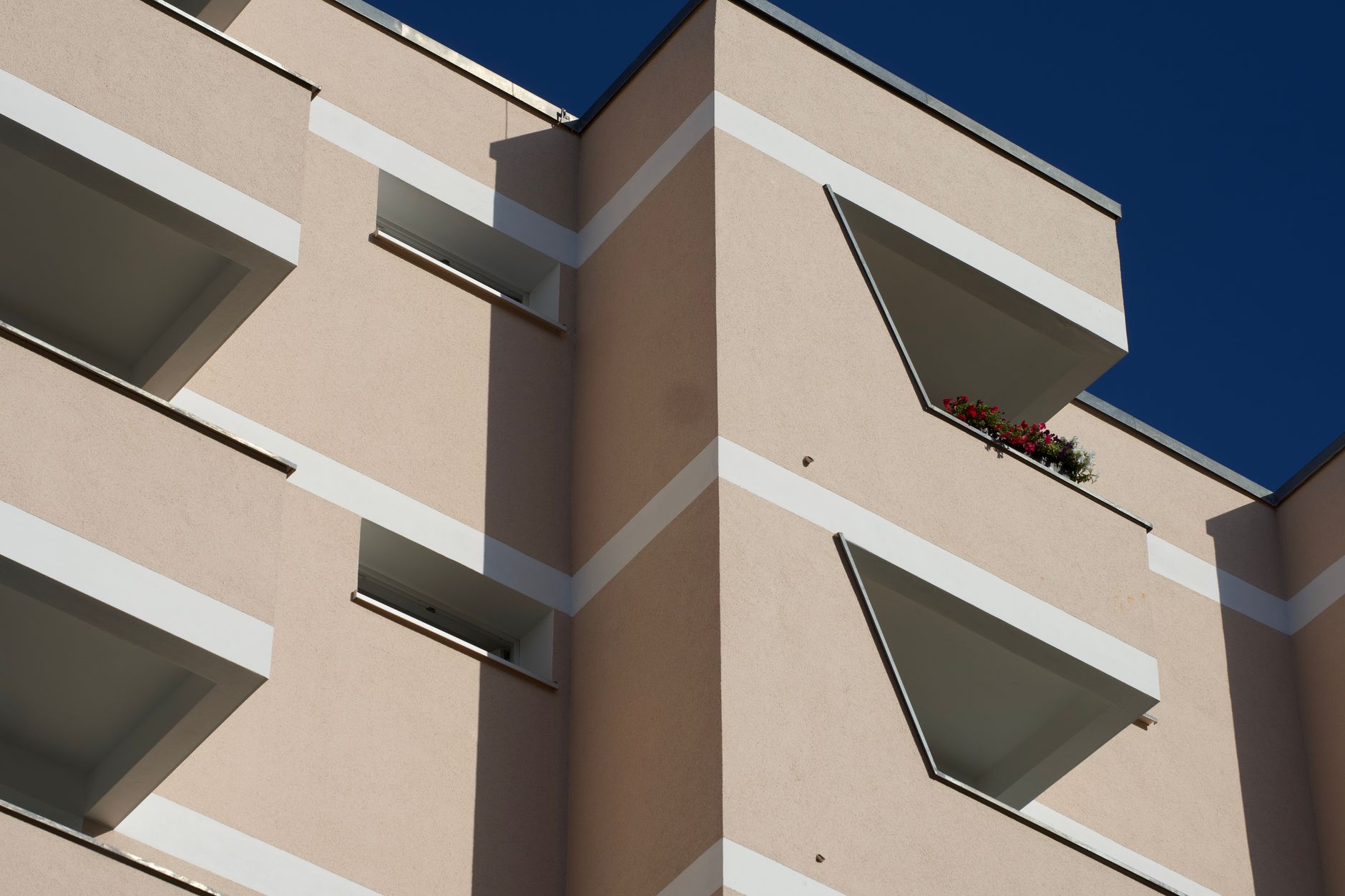 View of a modern apartment facade in Berlin, Germany with clear blue sky.
