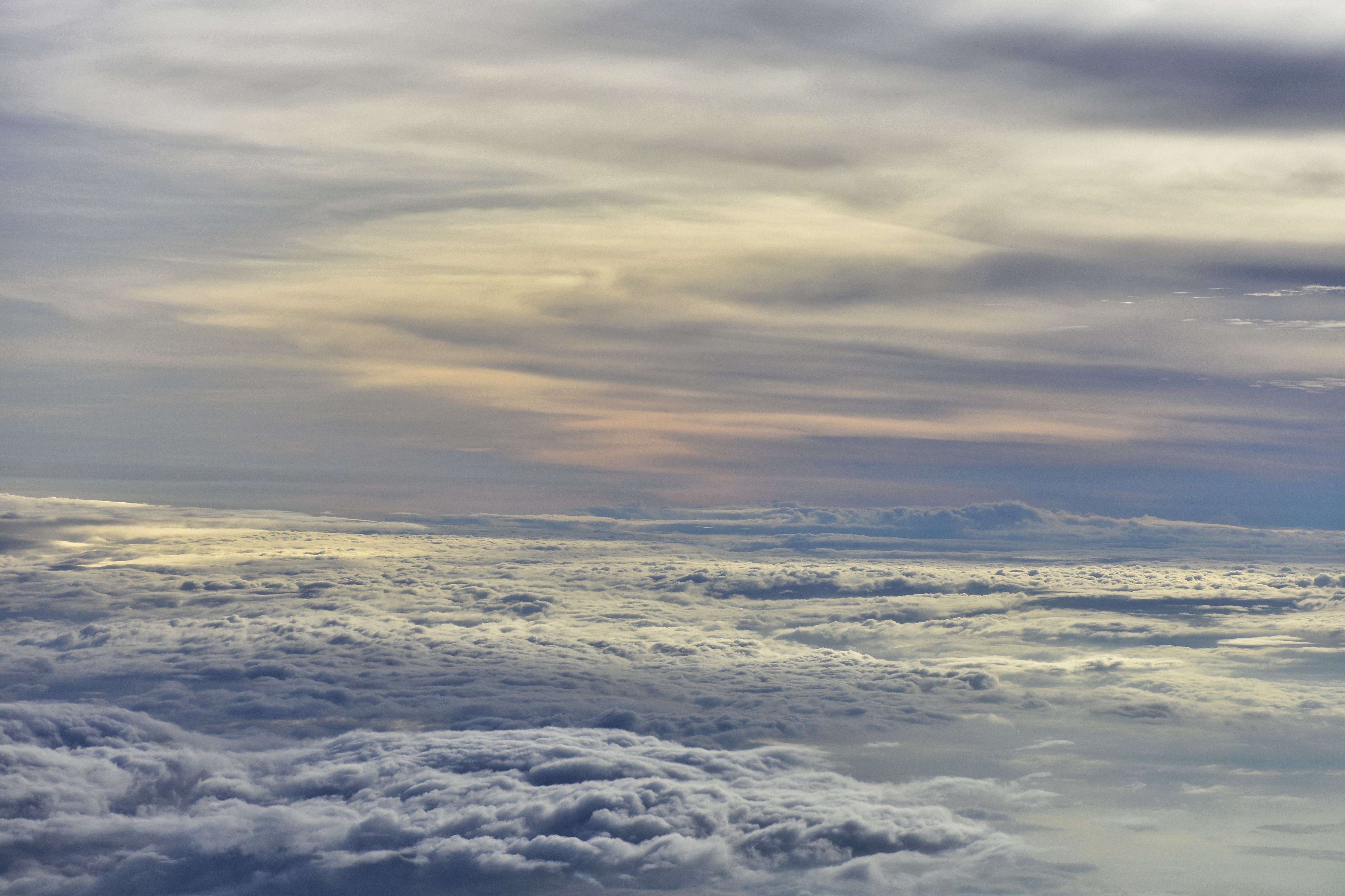 Stunning aerial view of clouds illuminated by sunset hues, creating a serene and dramatic sky scene.