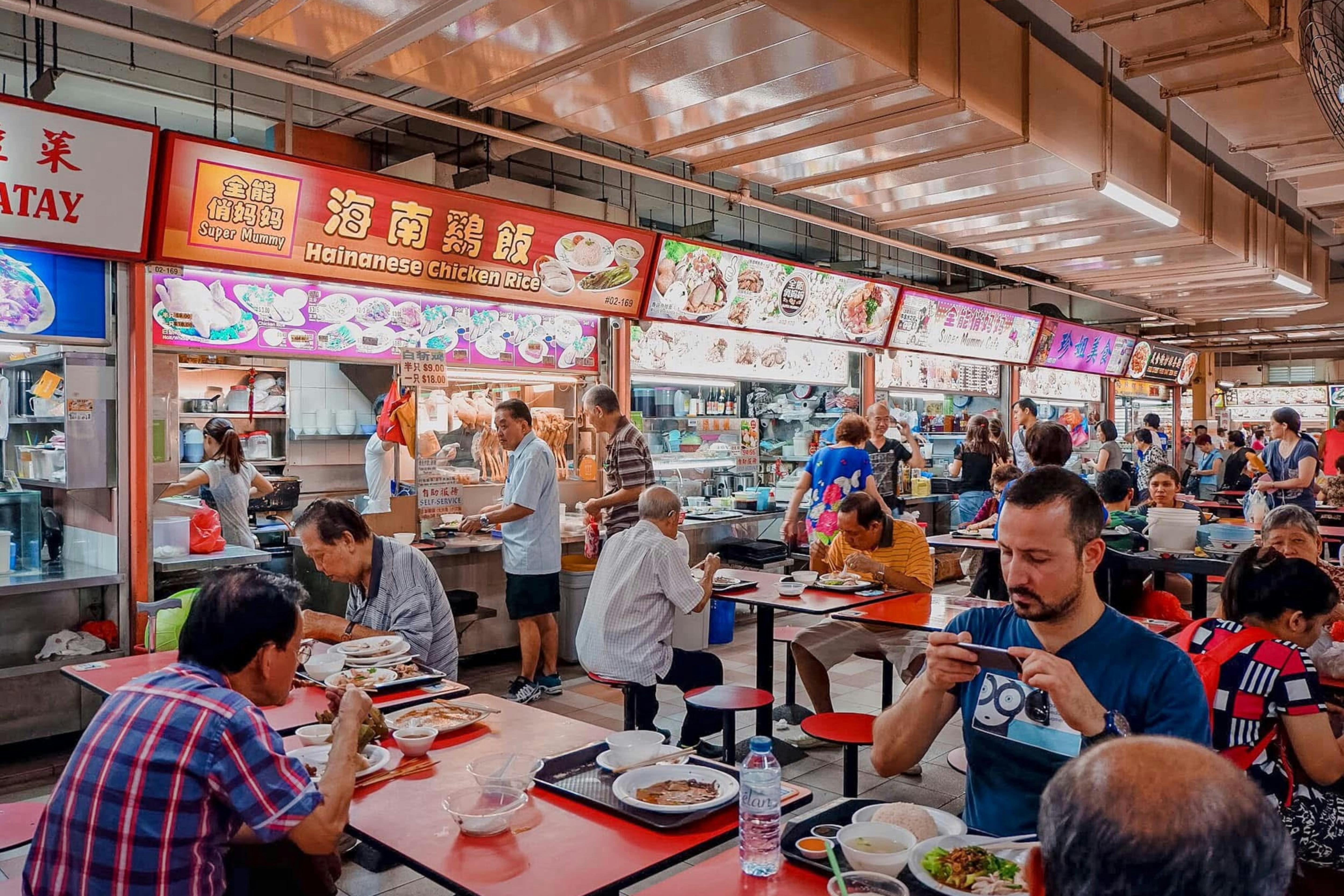 A bustling hawker center with diverse diners enjoying Singapore street food