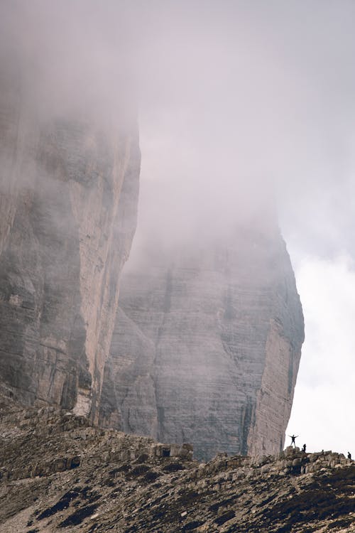 People Hiking in High Mountains Reaching Clouds 
