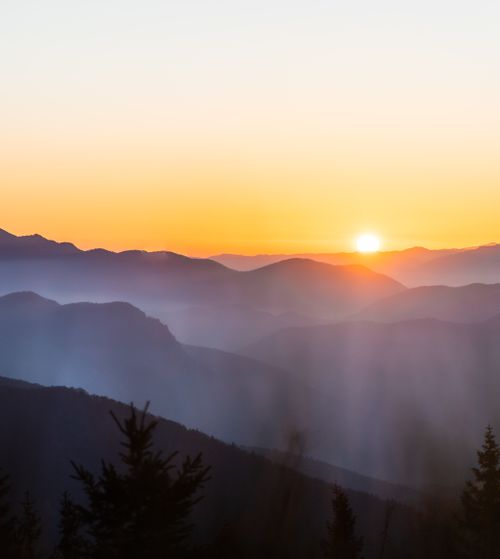 Free Beautiful sunset over foggy mountains creating a serene landscape view. Stock Photo