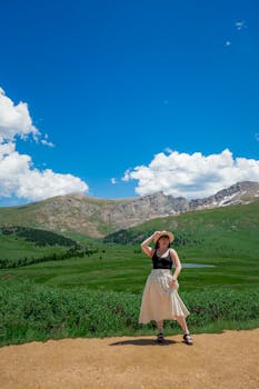 A stylish outdoor portrait of a woman in the Colorado Rockies during summer.