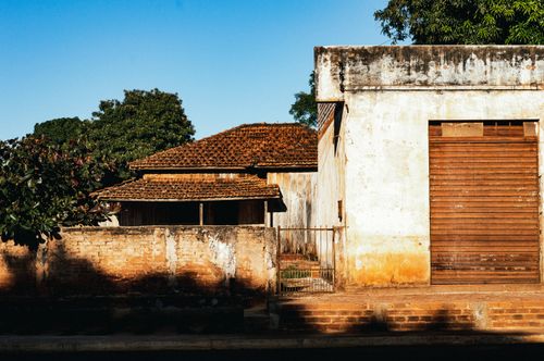 Free Old brick house with wooden roof and aged wall in bright daylight. Stock Photo