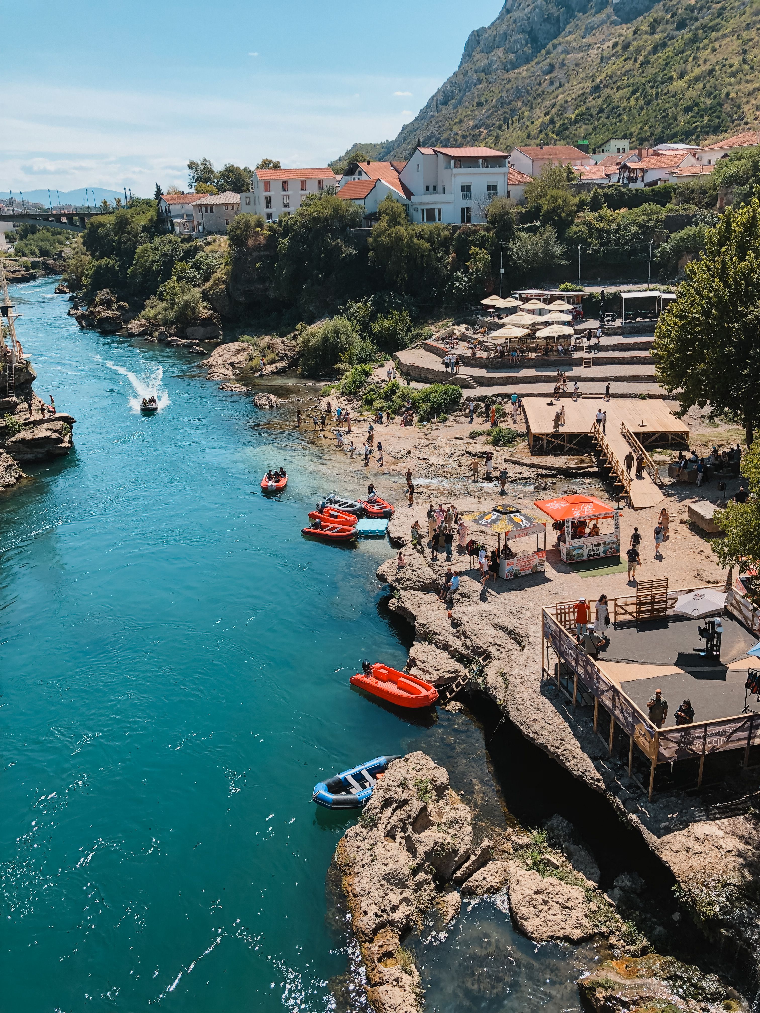 Scenic Riverside View with Boats and People · Free Stock Photo