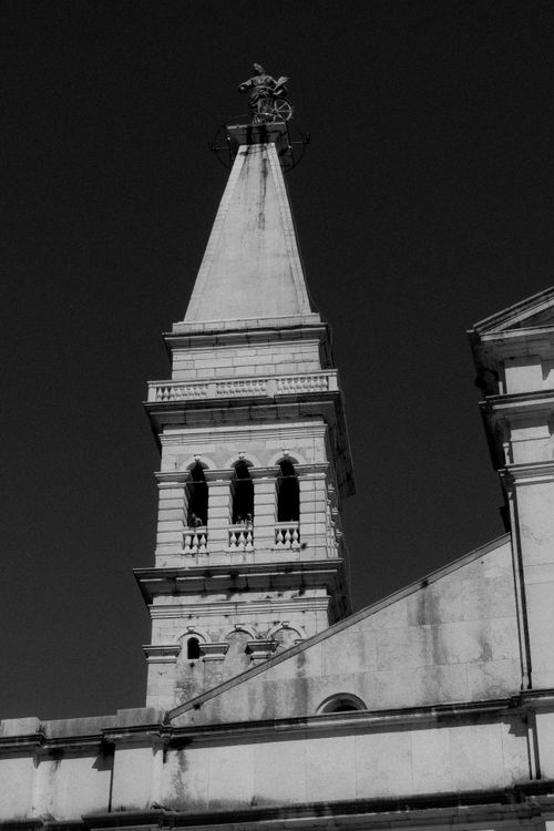 Free Dramatic black and white photo of a historic Croatian church tower, capturing architectural details. Stock Photo