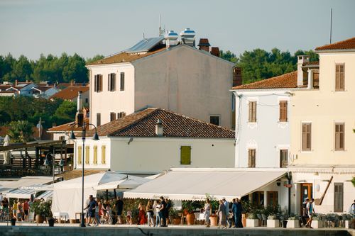 Free Scenic view of coastal buildings in Croatia with people enjoying a sunny day. Stock Photo