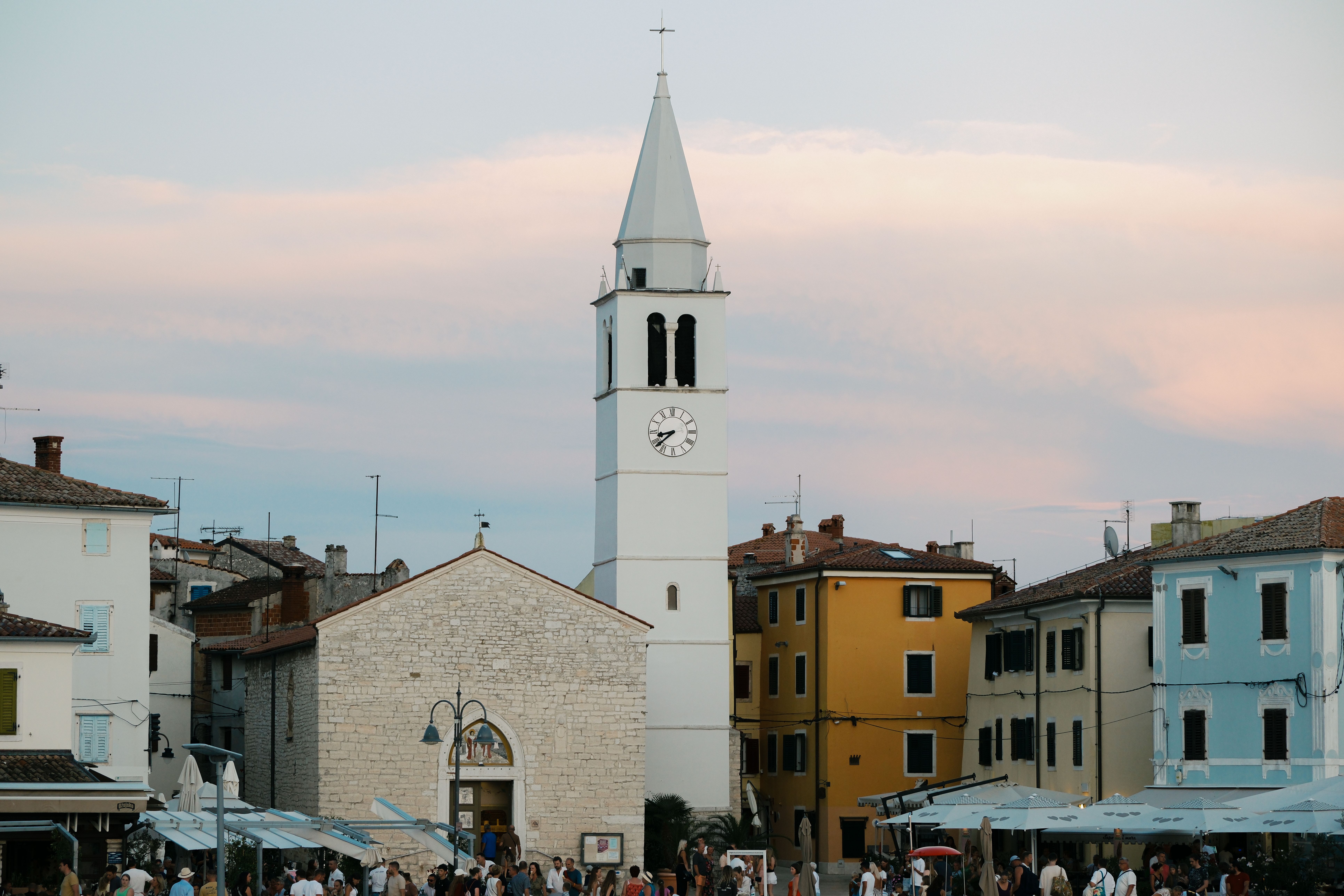 Picturesque evening view of a historic church tower in a Croatian town square.
