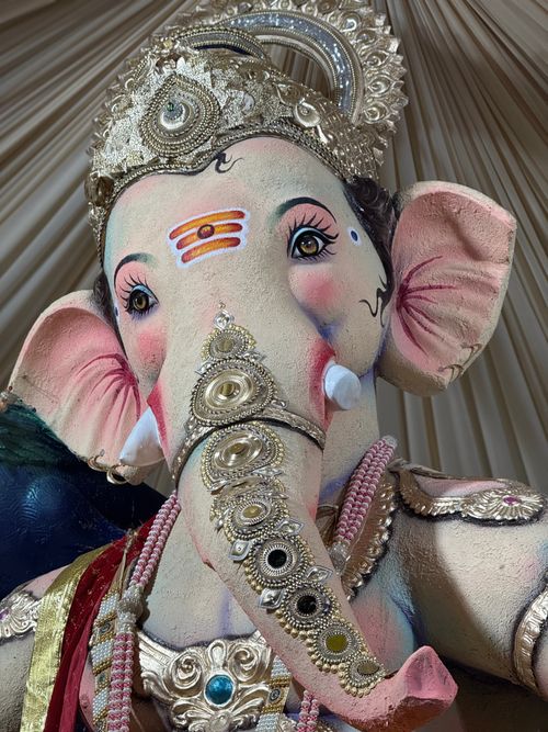Free Close-up of a detailed Ganesha idol showcasing ornate jewelry and vibrant decorations. Stock Photo