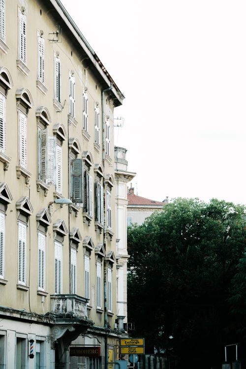 Free A vintage building facade in Croatia with classic shutters and lush greenery. Stock Photo