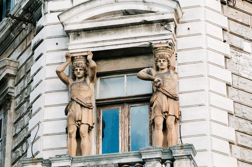 Free Detailed view of a historic Croatian building with classical sculptures framing a window. Stock Photo