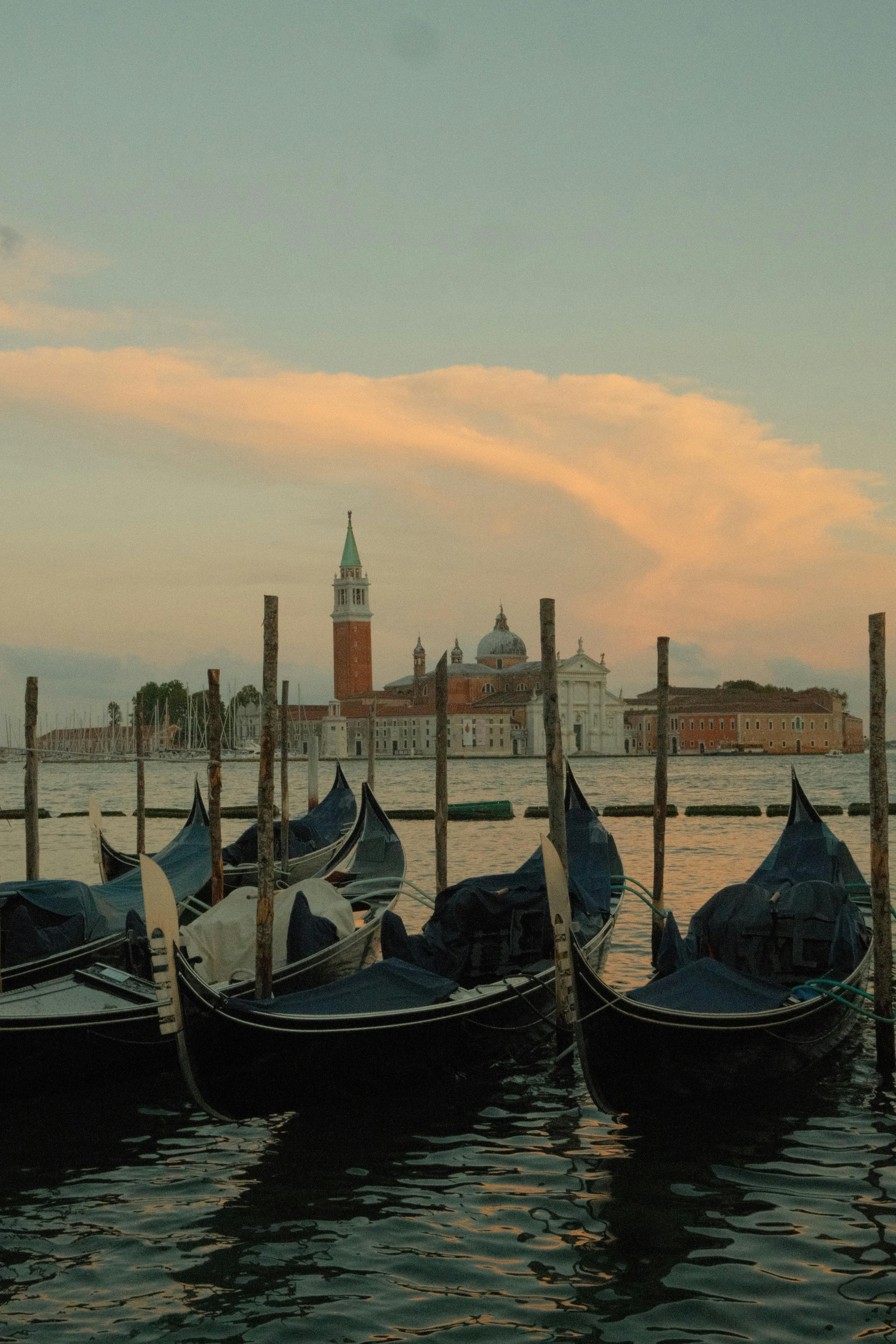 Serene evening view of gondolas and San Giorgio Maggiore in Venice under a pastel sky.