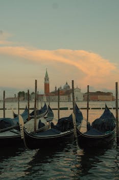 Serene evening view of gondolas and San Giorgio Maggiore in Venice under a pastel sky.