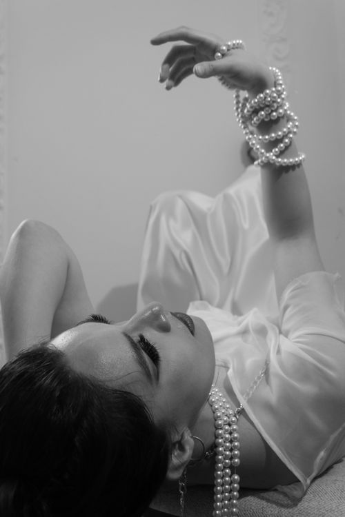 Free Sophisticated black and white portrait of a woman in elegant pose with pearl jewelry. Stock Photo