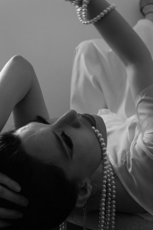 Free Black and white photo of a woman in a white dress adorned with pearls. Stock Photo