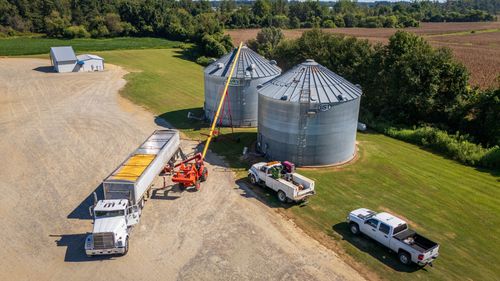 Free Aerial photograph capturing grain silos, trucks, and agricultural machinery on a North Carolina farm. Stock Photo