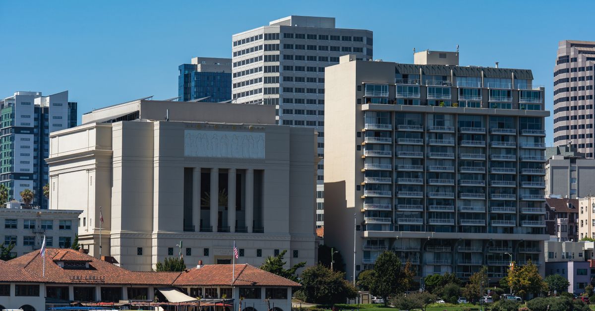 A picturesque urban skyline with modern buildings beside a serene waterfront on a sunny day.
