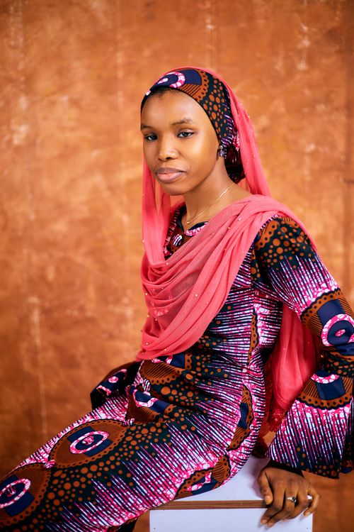 Free Elegant portrait of a woman in colorful traditional clothing with a warm background. Stock Photo