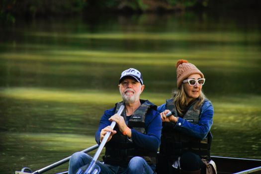 An elderly couple enjoys rowing on a tranquil lake, showcasing outdoor leisure and togetherness.