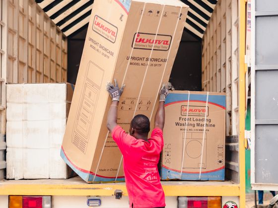 Worker loading a large appliance into the back of a truck for haul-away - KD Junk, Waxhaw NC