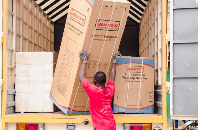 Worker loading a large appliance into the back of a truck for haul-away - KD Junk, Waxhaw NC