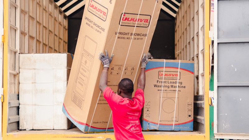 delivery workers carrying a new washing machine into a home