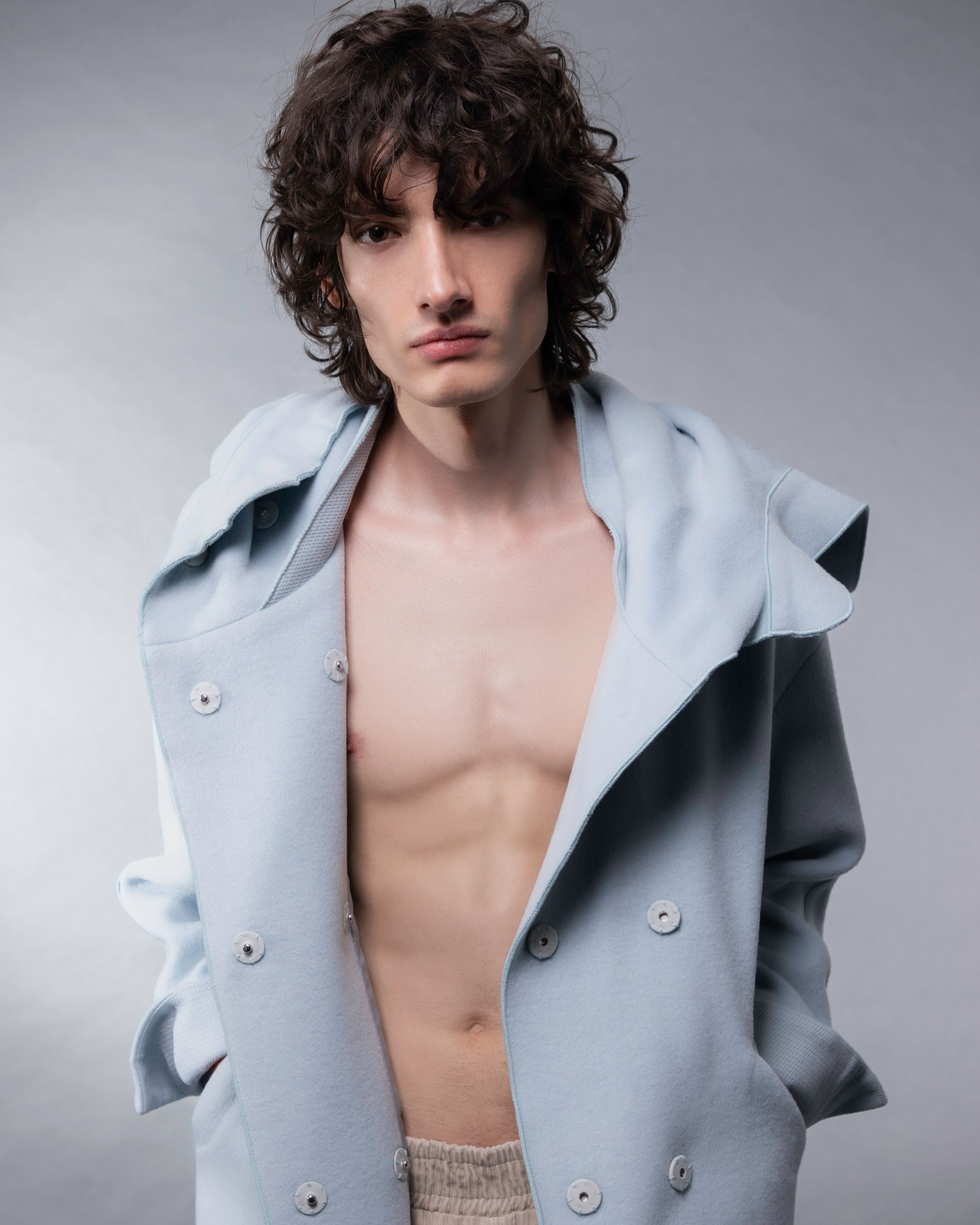 Portrait of a young male model in a fashionable outfit, showcasing modern style.