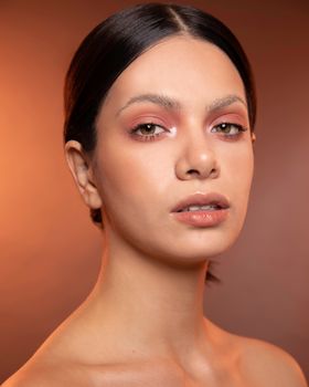 Minimalist portrait of an elegant woman with luminous skin and soft lighting.