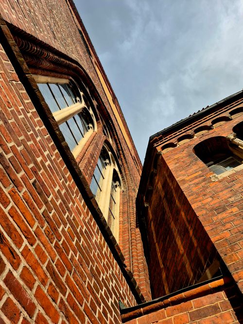 Free Upward view of red brick Gothic cathedral facade against the sky. Stock Photo