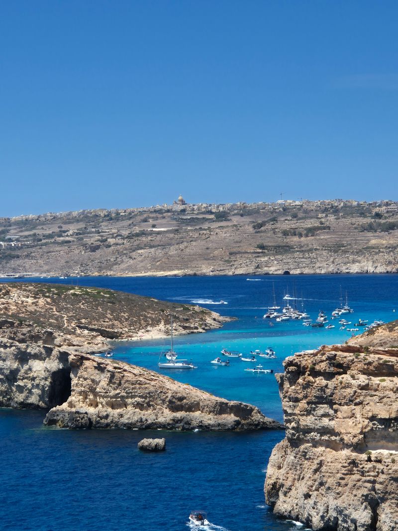 Boats anchored in the turquoise water of the Blue Lagoon on Comino, Malta