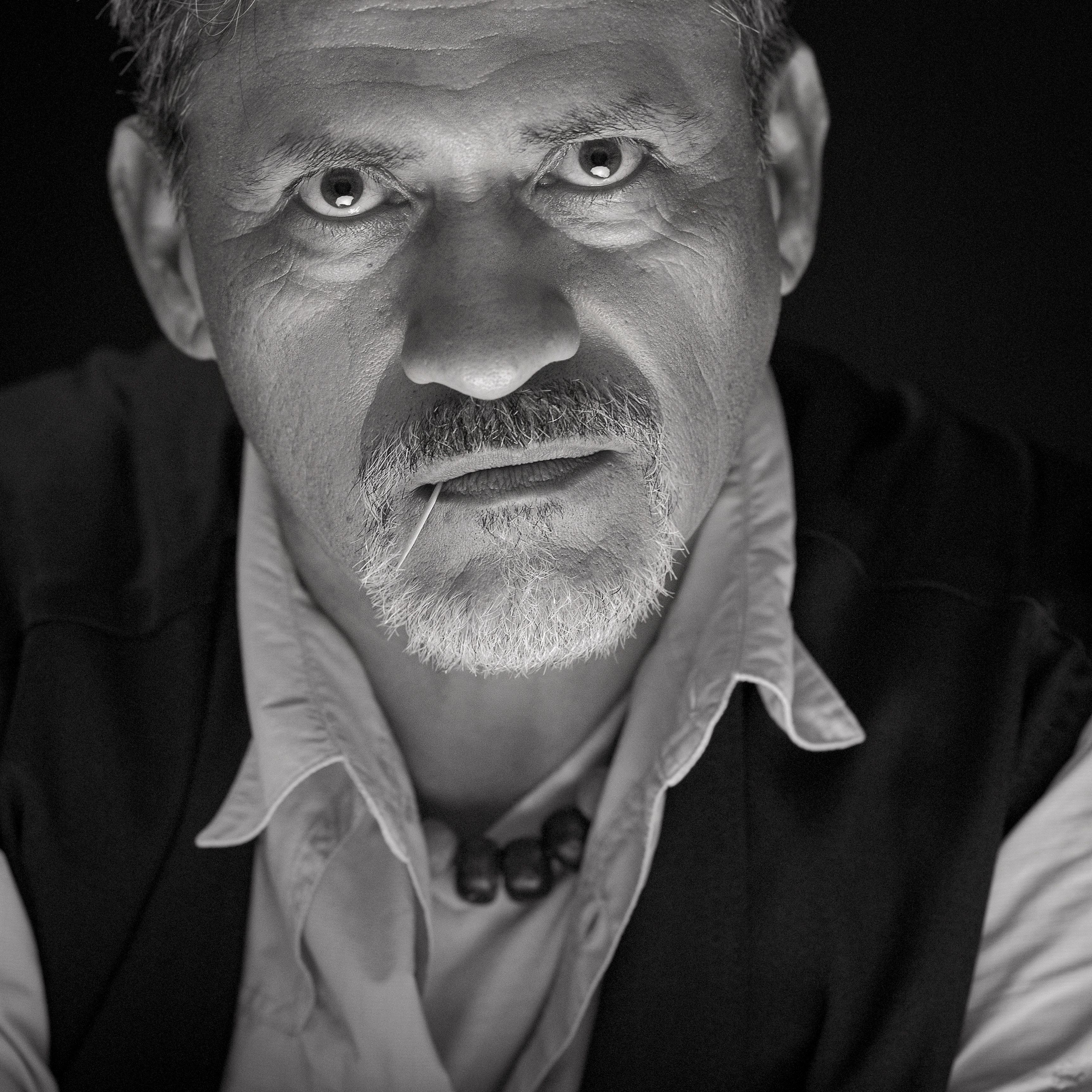 Close-up black and white portrait of a contemplative man with intense expression.