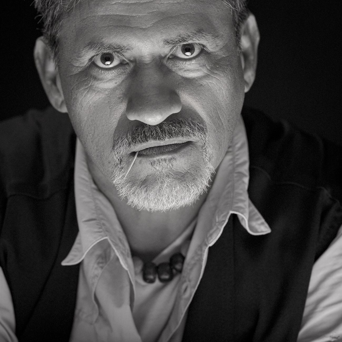 Close-up black and white portrait of a contemplative man with intense expression.