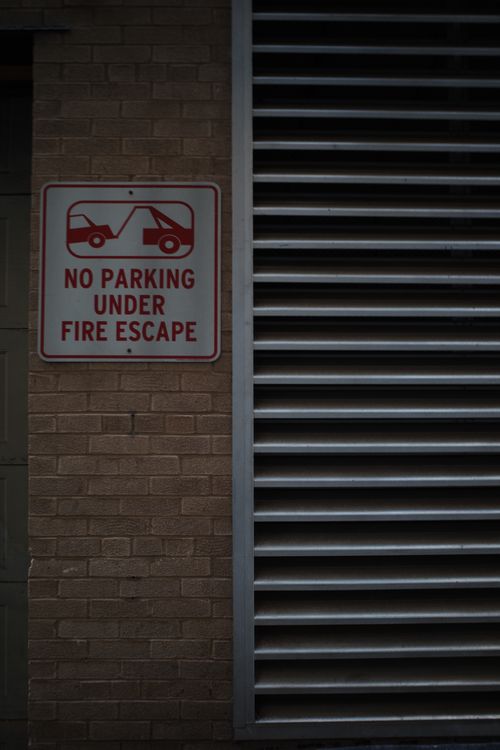 Free No parking sign on a brick wall in an urban setting highlighting building safety. Stock Photo