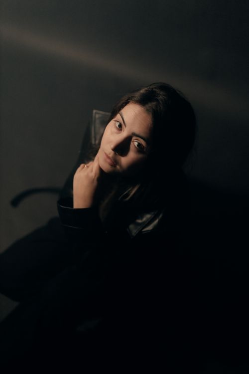Free A mysterious portrait of a woman in dark, moody lighting, conveying introspection. Stock Photo