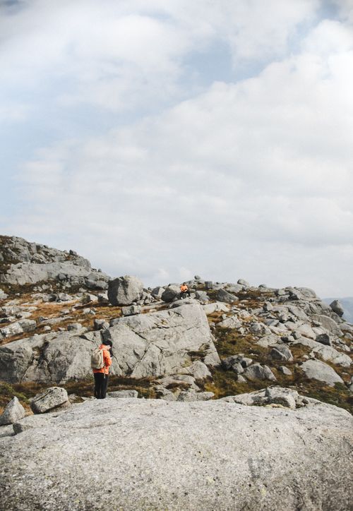 Free Two hikers explore a rocky landscape under a partly cloudy sky. Stock Photo